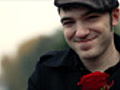 Young man holding red rose,  giving a kiss