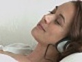 Woman relaxing with music lying on sofa