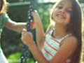 Girls play on a tire swing