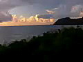 Royalty Free Stock Video SD Footage Static Shot Then Zoom In and Out to Mountain Range and Inlet at Sunrise on Beach in Kauai,  Hawaii