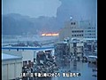 Japanese watch Kesennuma city burn,  fiery debris floats past in flooded streets