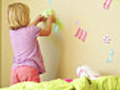 Adorable girl decorates her room.