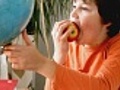 Young boy eating apple and looking at the globe