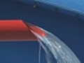 Water jet from red tube; game attraction detail in waterpark