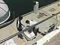 Royalty Free Stock Video SD Footage Crew Members Prepare to Load a Life Raft Container on a Large Yacht Docked on the Intracoastal Waterway in Ft. Lauderdale,  Florida