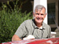 Portrait of senior man polishing car