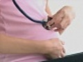 Close up of pregnant woman using a stethoscope