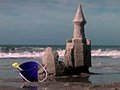 1003 Crumbling Beach Sand Castle Ocean Waves And Toys Stock Footage