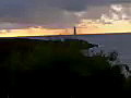 Royalty Free Stock Video SD Footage Light Beacon Flashes Light With Rain Clouds on Horizon at Sunrise on Beach in Kauai,  Hawaii