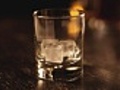 Whiskey glass filled with ice and drink,  close-up