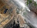 Daredevil flies through a waterfall wearing a wingsuit