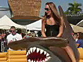 Royalty Free Stock Video HD Footage Girl Rides a Bucking Shark at a Carnival in South Florida