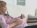 Relaxed pregnant woman using a stethoscope