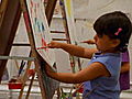 A Girl Paints At An Easel
