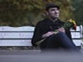 Man on park bench waiting for date,  looking at watch