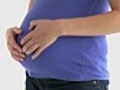 Close up of a pregnant woman touching her belly