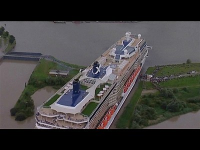 Giant ship squeezes through tiny canal