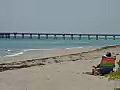 Royalty Free Stock Video HD Footage Woman in Beach Chair Viewing Pier and Beach Scene in Ft. Lauderdale,  Florida