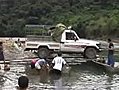 Truck Rides Canoes Across River