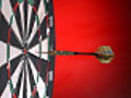 Dart hits bulls-eye on dartboard,  slow motion