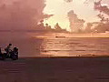 Royalty Free Stock Video HD Footage Static Shot of Ft. Lauderdale Beach at Sunrise With Ship on Horizon as Runabout Leaves Area