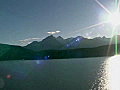 Royalty Free Stock Video SD Footage Zoom Out From a Large Mountain Range to Bright Sun in Prince William Sound,  Alaska