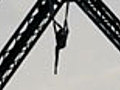 Acrobat Hangs From Bridge