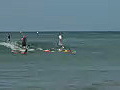 Royalty Free Stock Video HD Footage Three Surfers Ride a Wave at Waikiki Beach in Honolulu,  Hawaii