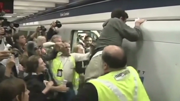 Protester climbs on top of BART train