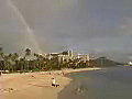 Royalty Free Stock Video SD Footage Static Shot With Rainbow in Sky Then Slow Zoom Diamond Head at Honolulu Hawaii as People Walk Along Waikiki Beach