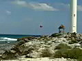 Royalty Free Stock Video SD Footage Zoom Out to Scenic View of Point and Lighthouse on Cancun Beach in Mexico