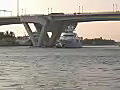 Royalty Free Stock Video HD Footage Work Boat Tows a Luxury Yacht Under the Bridge in Ft. Lauderdale,  Florida